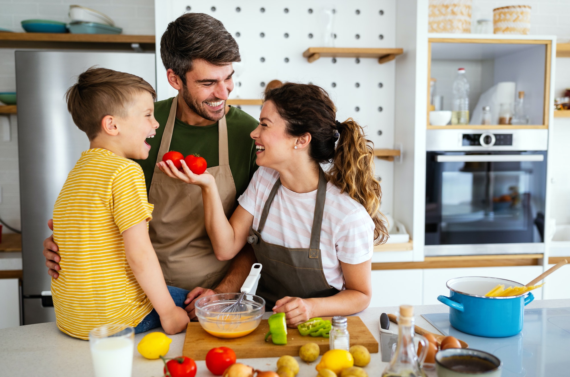 Happy family in the kitchen having fun and cooking together. Healthy food at home